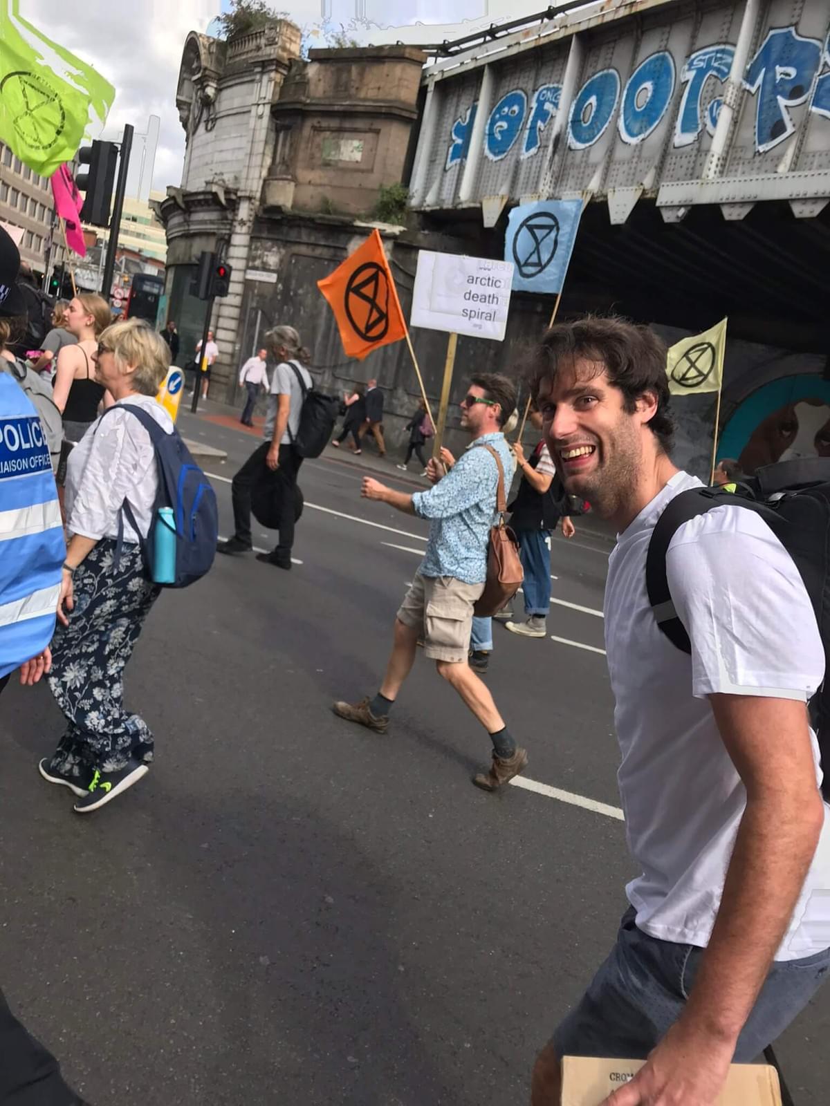 Sam walking down the street amongst Extinction Rebellion protesters Sam walking down the street amongst Extinction Rebellion protesters