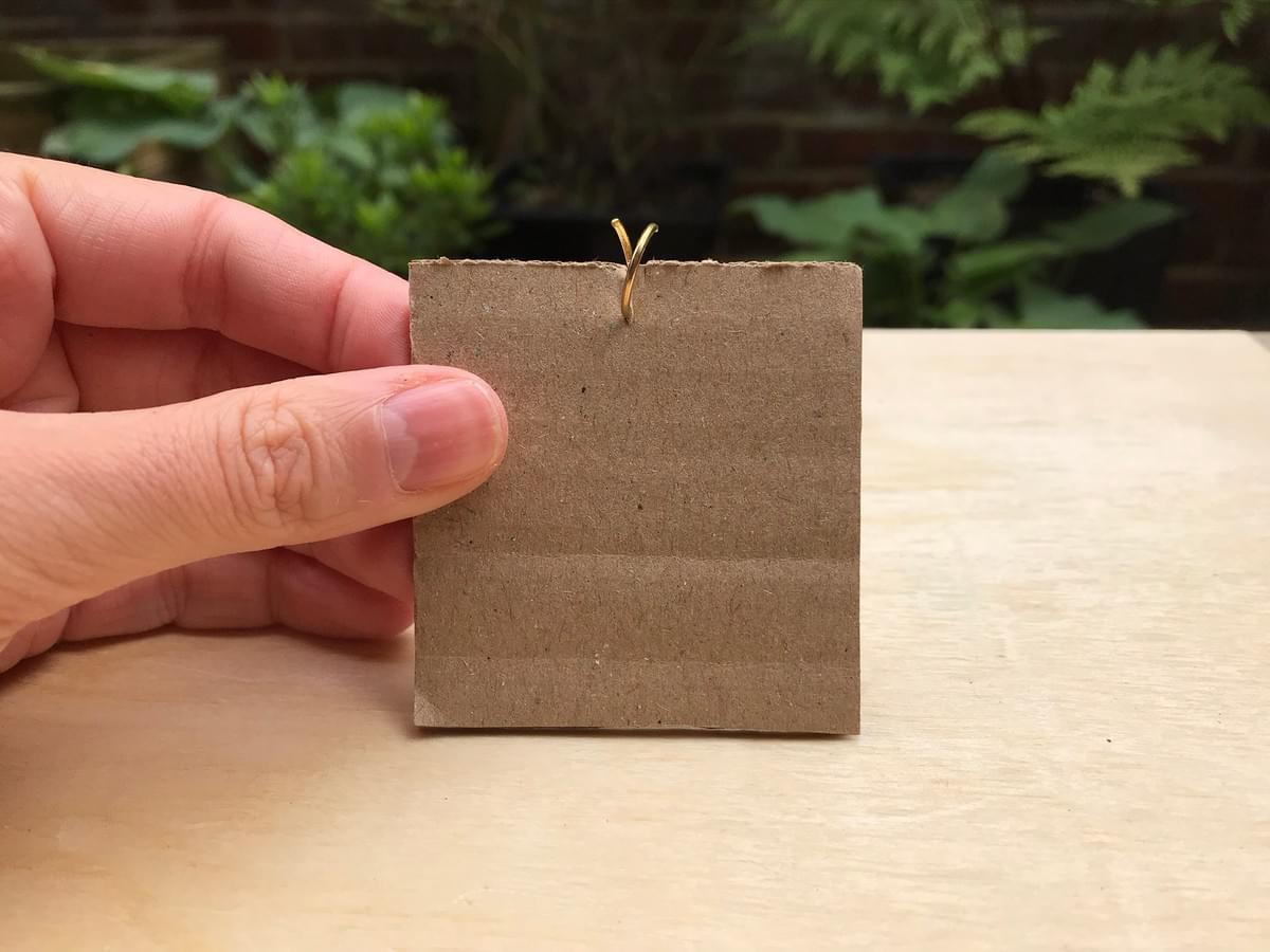 Hand holding card, showing the ring slotted in to the small cut Hand holding card, showing the ring slotted in to the small cut