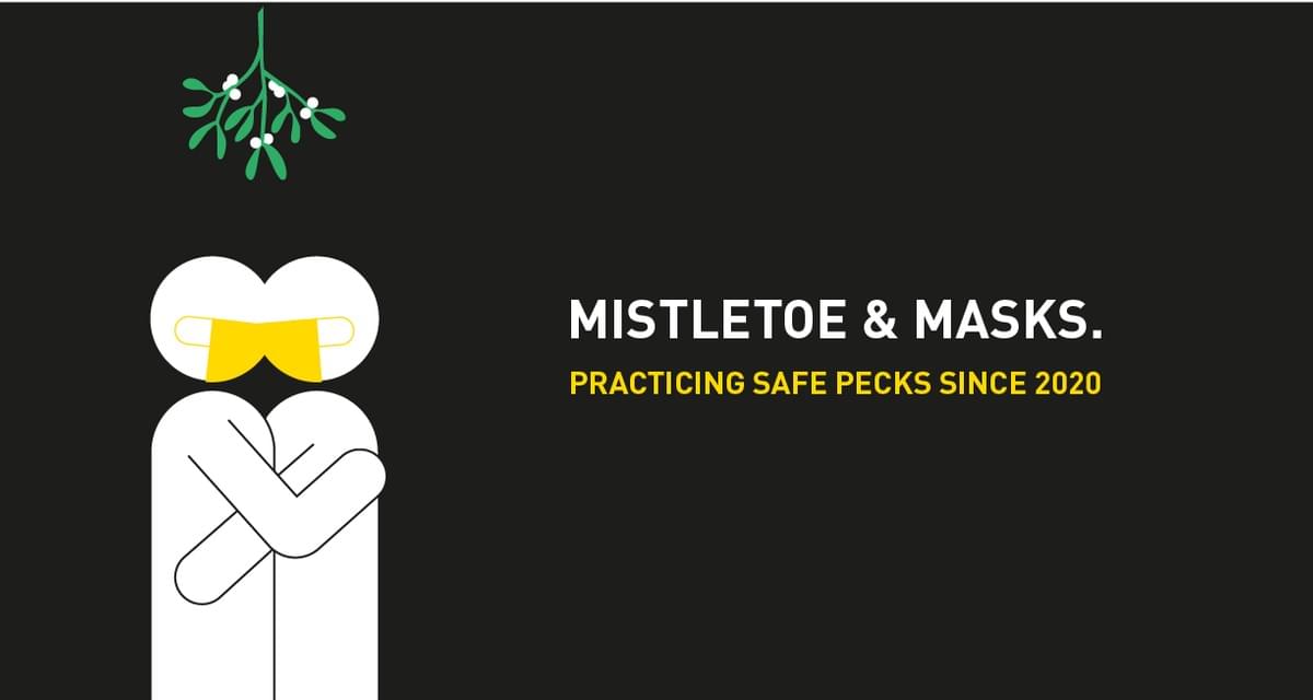 Two white stick figures with yellow face masks in an embrace under the mistletoe Two white stick figures with yellow face masks in an embrace under the mistletoe