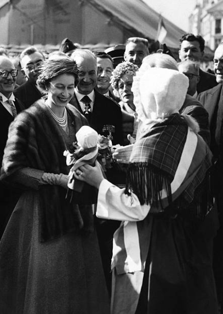 Lille 11 avril 1957, Vieille Bourse, Elizabeth II reçoit des mains d'une jeune Lilloise une poupée des Flandres Lille 11 avril 1957, Vieille Bourse, Elizabeth II reçoit des mains d'une jeune Lilloise une poupée des Flandres