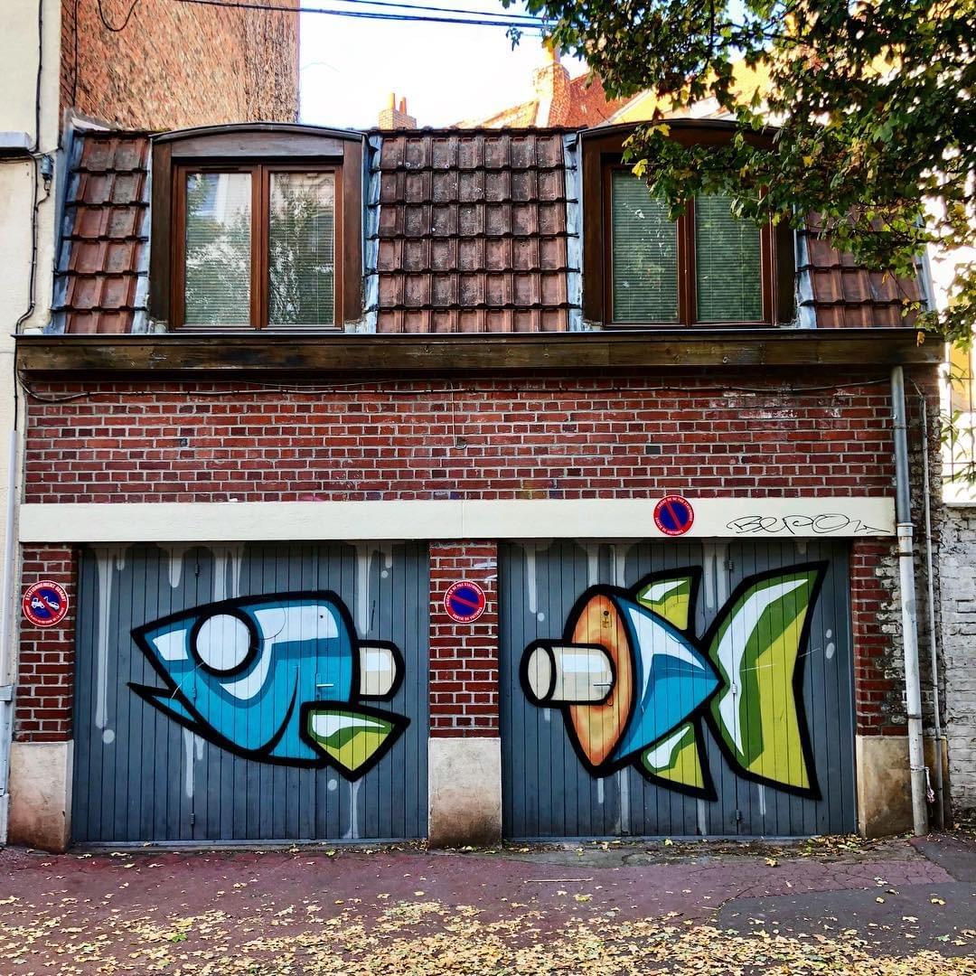 à Lille, une énorme graffiti représentant un poisson en couleurs. le poisson est coupé en deux et est peint sur deux portes de garage. Il a été réalisé par le collectif poissons. à Lille, une énorme graffiti représentant un poisson en couleurs. le poisson est coupé en deux et est peint sur deux portes de garage. Il a été réalisé par le collectif poissons.