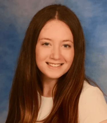 Danielle Goodstein, who wrote about behavioral economics and golf for her Horizon Academic high school research project. She has long red hair, is wearing a white shirt, and is on a cloudy blue black ground. Danielle Goodstein, who wrote about behavioral economics and golf for her Horizon Academic high school research project. She has long red hair, is wearing a white shirt, and is on a cloudy blue black ground.