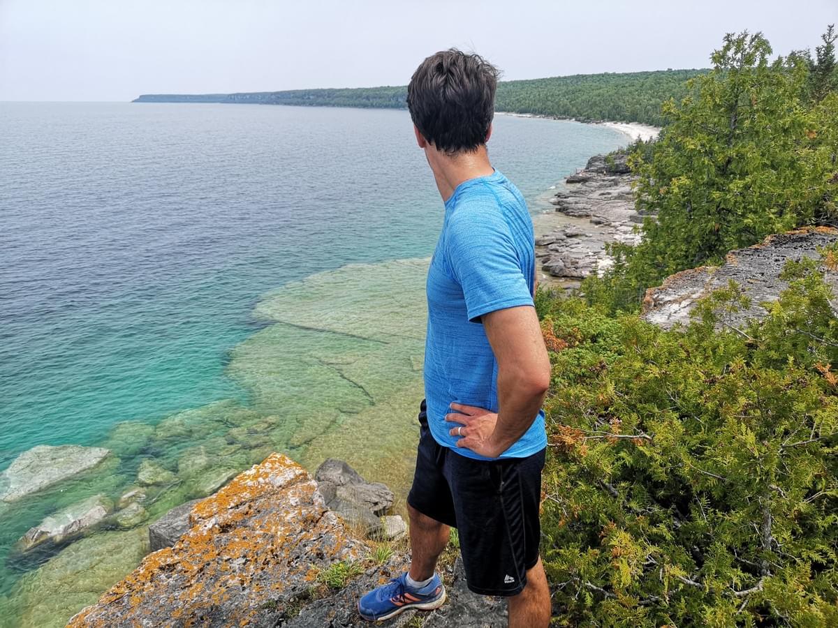 man standing on a cliff overlooking Bruce Peninsula, Georgian Bay, Ontario man standing on a cliff overlooking Bruce Peninsula, Georgian Bay, Ontario