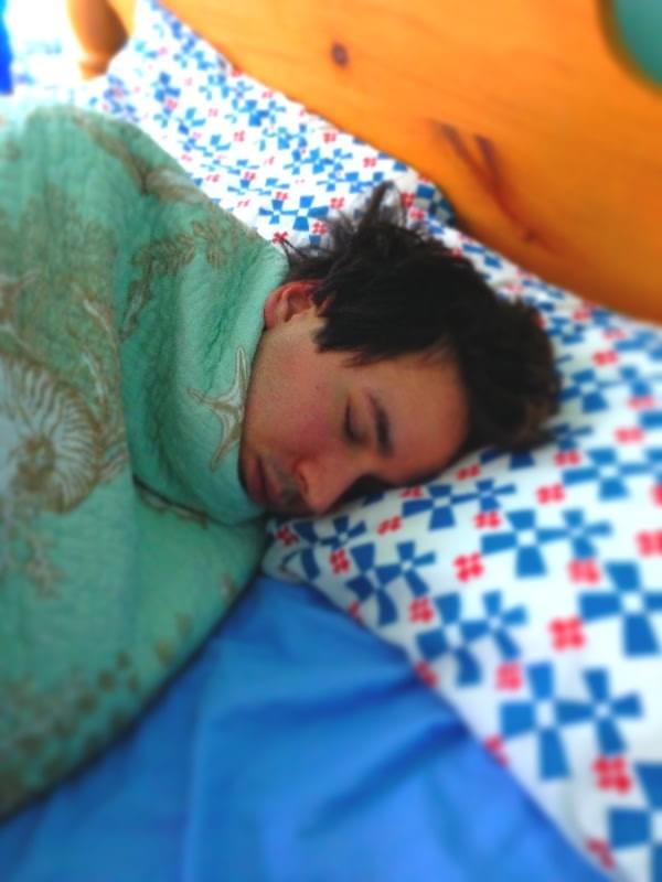 man with brown hair sleeping under ocean themed blankets man with brown hair sleeping under ocean themed blankets