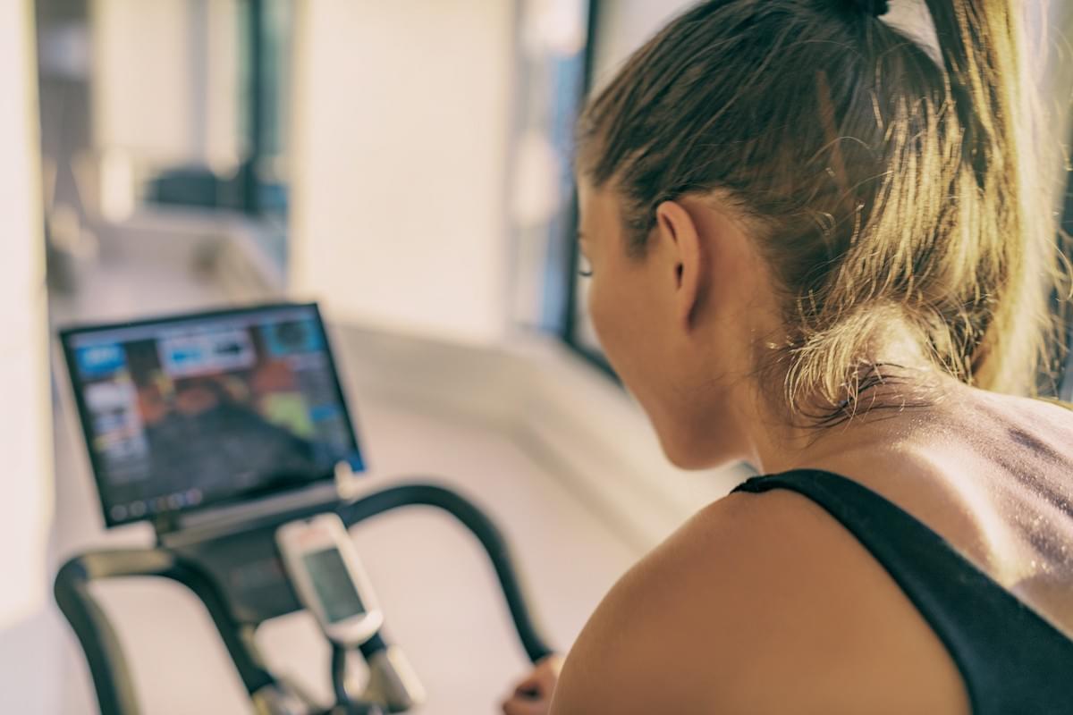 Femme faisant du vélo à l'intérieur, devant un écran . Cyclisme intérieur, femme, exercice physique, vélo, cyclisme, sport, adaptation, objet connecté, intérieur, confinement, santé, effort physique, entraînement Femme faisant du vélo à l'intérieur, devant un écran . Cyclisme intérieur, femme, exercice physique, vélo, cyclisme, sport, adaptation, objet connecté, intérieur, confinement, santé, effort physique, entraînement