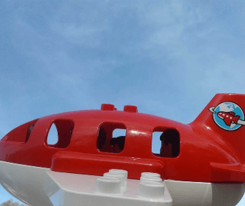 Duplo plane flies through a blue sky Duplo plane flies through a blue sky
