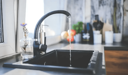 Photo of a tap running in a kitchen Photo of a tap running in a kitchen