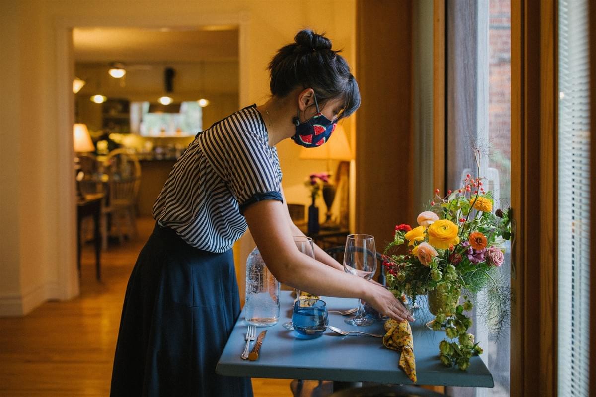 Florist Rachel Kwan sets a dinner table with cloth napkins and local flower arrangement. Florist Rachel Kwan sets a dinner table with cloth napkins and local flower arrangement.