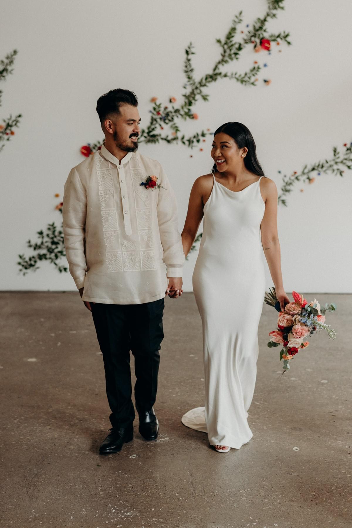 Bride and groom before their ceremony at Airship37. Groom wears traditional barong and bride wears sleek cream dress. Bride and groom before their ceremony at Airship37. Groom wears traditional barong and bride wears sleek cream dress.