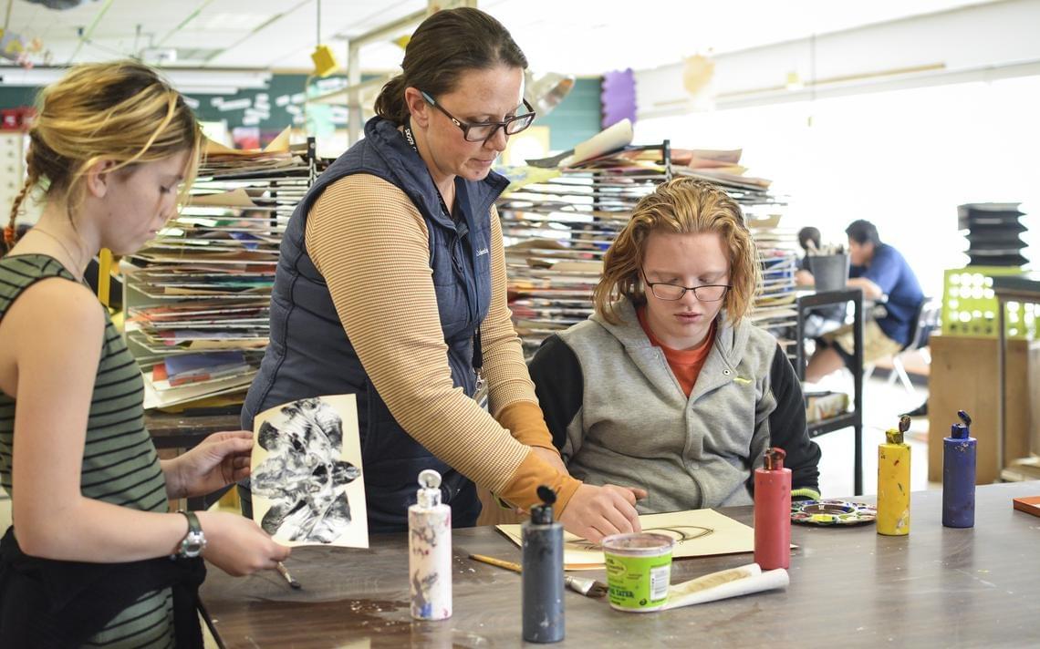 Middle school art teacher Molly Wiste (center) talks to Laura Dawes (right) about her art project during their eighth-grade 2D art class at the Bemidji Middle School. (Annalise Braught | Bemidji Pioneer) Middle school art teacher Molly Wiste (center) talks to Laura Dawes (right) about her art project during their eighth-grade 2D art class at the Bemidji Middle School. (Annalise Braught | Bemidji Pioneer)