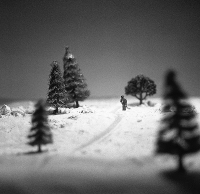 Miniature snow scene created with flour, small model trees and a small man with a shovel digging a path Miniature snow scene created with flour, small model trees and a small man with a shovel digging a path