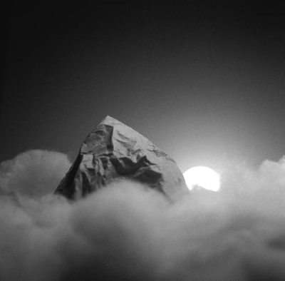Paper mountain through soft toy filling clouds with a setting sun behind Paper mountain through soft toy filling clouds with a setting sun behind