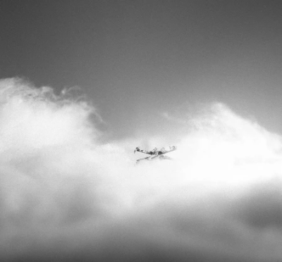 Miniature x-wing flying through soft toy filling clouds in black and white Miniature x-wing flying through soft toy filling clouds in black and white