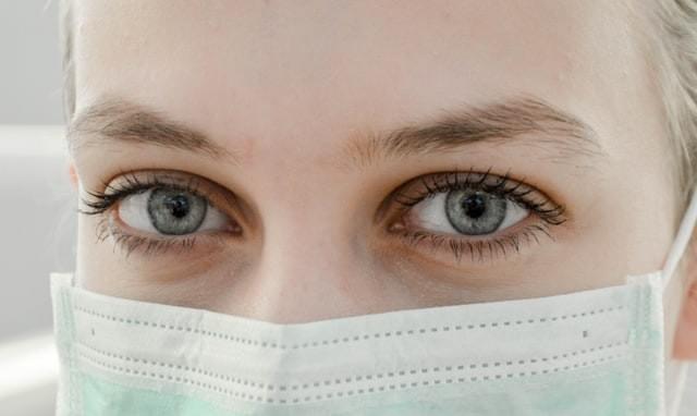 Close image of woman's eyes. She is wearing a medical face mask Close image of woman's eyes. She is wearing a medical face mask