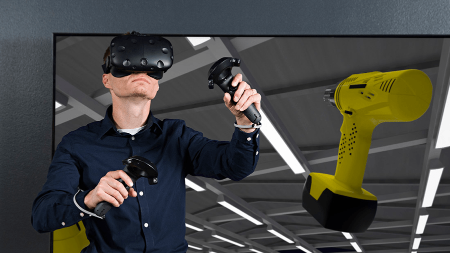 An image of a male wearing VIVE and two handles, controlling a virtual drill An image of a male wearing VIVE and two handles, controlling a virtual drill