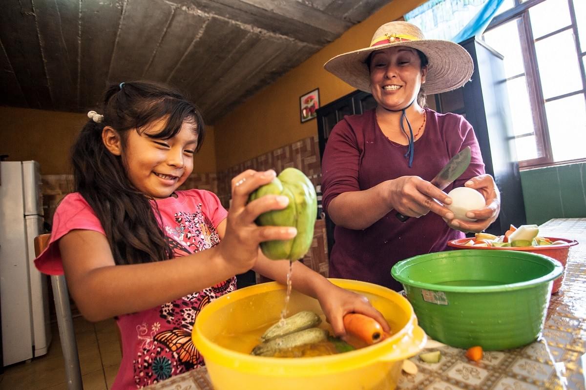 Mujer y niña lavando verduras. Foto: One Drop / Terry Hughes. Mujer y niña lavando verduras. Foto: One Drop / Terry Hughes.