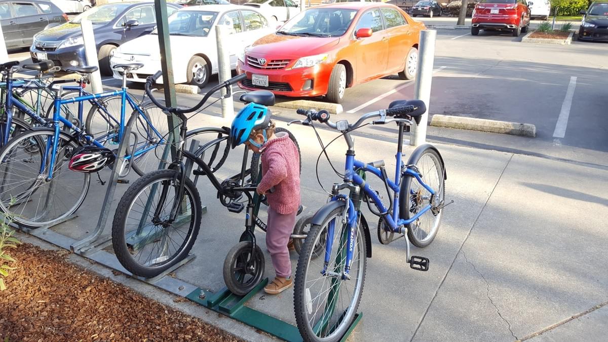 Nico's 3-1/2 year old son parks his bicycle in the bike rack. Nico's 3-1/2 year old son parks his bicycle in the bike rack.