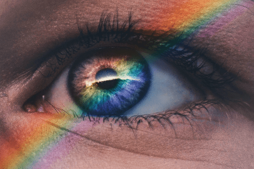 A thin line of rainbow imposed over a close up photo of someones eye. A thin line of rainbow imposed over a close up photo of someones eye.