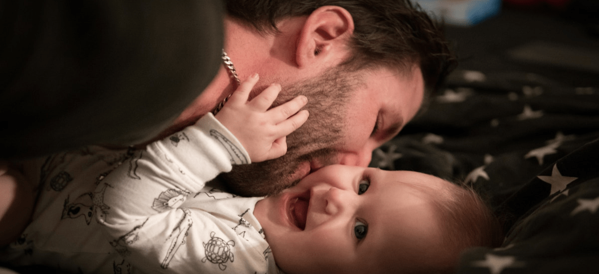 A father gives a kiss to his newborn child A father gives a kiss to his newborn child
