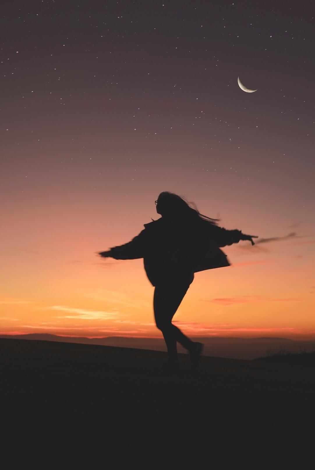 A woman twirling with the background of a sunset as featured in the blog post "6 Tips to Worry Less" from The Purple Dog Vegan A woman twirling with the background of a sunset as featured in the blog post "6 Tips to Worry Less" from The Purple Dog Vegan
