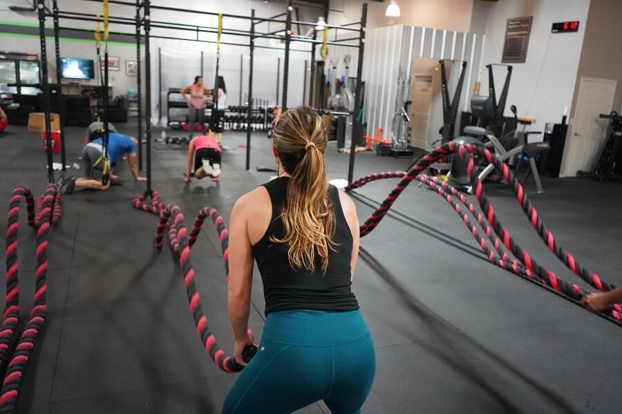 A photo of a woman using battle ropes while exercising during a workout, photo featured in the blog post "A Love Letter to Battle Ropes" by The Purple Dog Vegan A photo of a woman using battle ropes while exercising during a workout, photo featured in the blog post "A Love Letter to Battle Ropes" by The Purple Dog Vegan