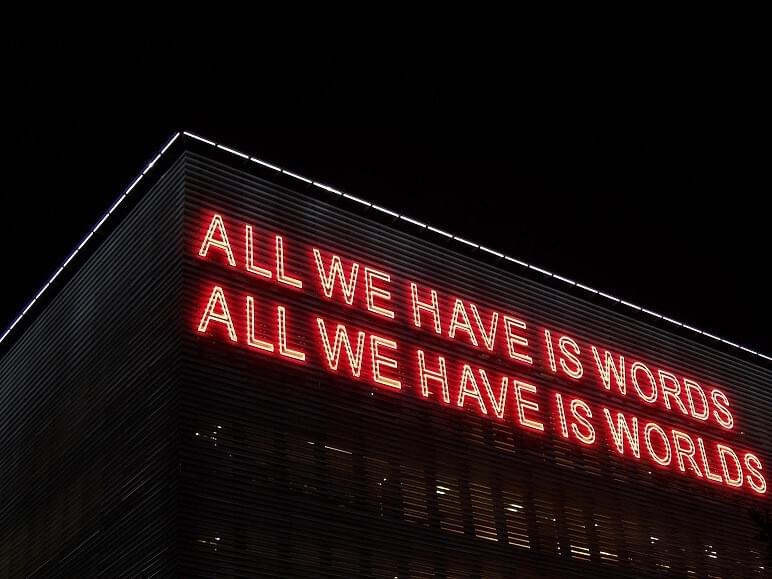 The Words We Use Say More than We Think- blog post by The Purple Dog Vegan- this pic is a building with the words "All we have The Words We Use Say More than We Think- blog post by The Purple Dog Vegan- this pic is a building with the words "All we have