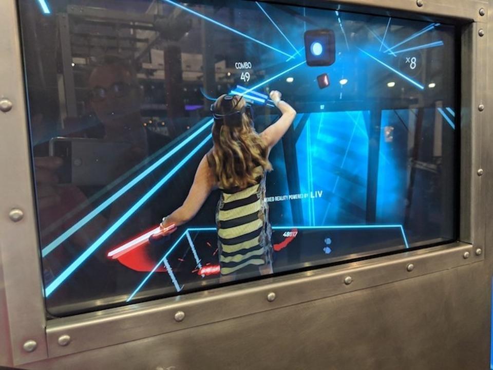 Beat Saber in an Exit-VR single player enclosure. This monitor is showing a real-time composite of the player inside and outside the simulation. Charlie Fink Beat Saber in an Exit-VR single player enclosure. This monitor is showing a real-time composite of the player inside and outside the simulation. Charlie Fink