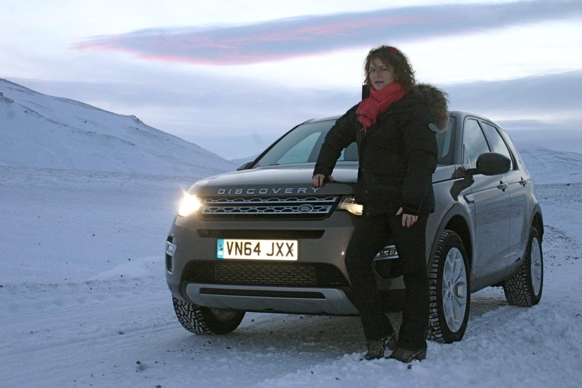 Anne-Charlotte Laugier devant un Land Rover Discovery gris en Islande Anne-Charlotte Laugier devant un Land Rover Discovery gris en Islande