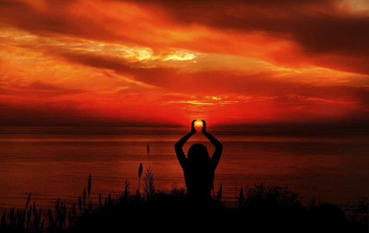 Image of a sunset over a calm sea, with a praying figure seeming to cup the sun in her hands. (Courtesy of Dreamstime) Image of a sunset over a calm sea, with a praying figure seeming to cup the sun in her hands. (Courtesy of Dreamstime)