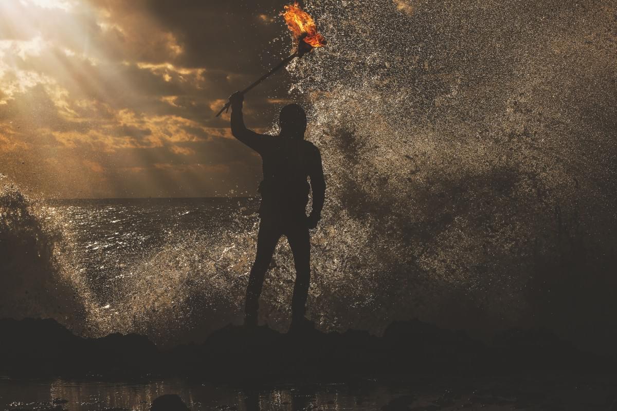 Image of a tribal warrior holding aloft a flaming torch whilst the sea breaks against him and the sun illuminates the spray. (Courtesy of Dreamstime) Image of a tribal warrior holding aloft a flaming torch whilst the sea breaks against him and the sun illuminates the spray. (Courtesy of Dreamstime)