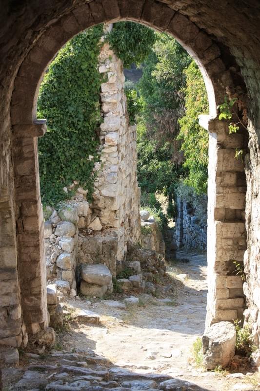 Image of a rural and rustic garden seen through an old arch. Image of a rural and rustic garden seen through an old arch.