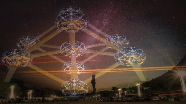 A figure silhouetted against stars. There is a model of the atom filling the sky. A figure silhouetted against stars. There is a model of the atom filling the sky.