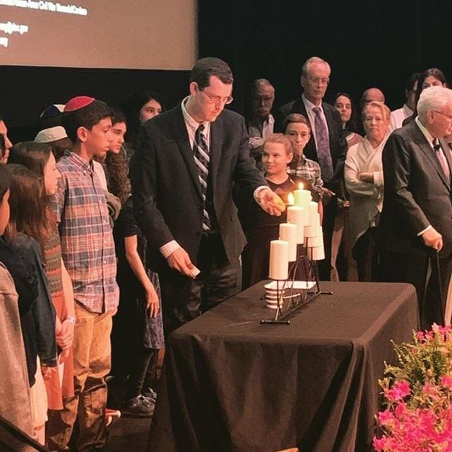 Daniel Kuhn lights a memorial candle at the annual Federal Inter-Agency Holocaust Remembrance Program on April 30th at the Lincoln Theater. Daniel Kuhn lights a memorial candle at the annual Federal Inter-Agency Holocaust Remembrance Program on April 30th at the Lincoln Theater.