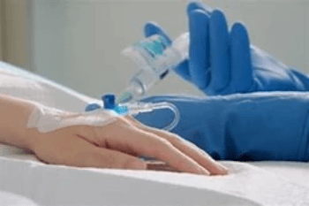 A chemo patients hand is being injected with treatment A chemo patients hand is being injected with treatment