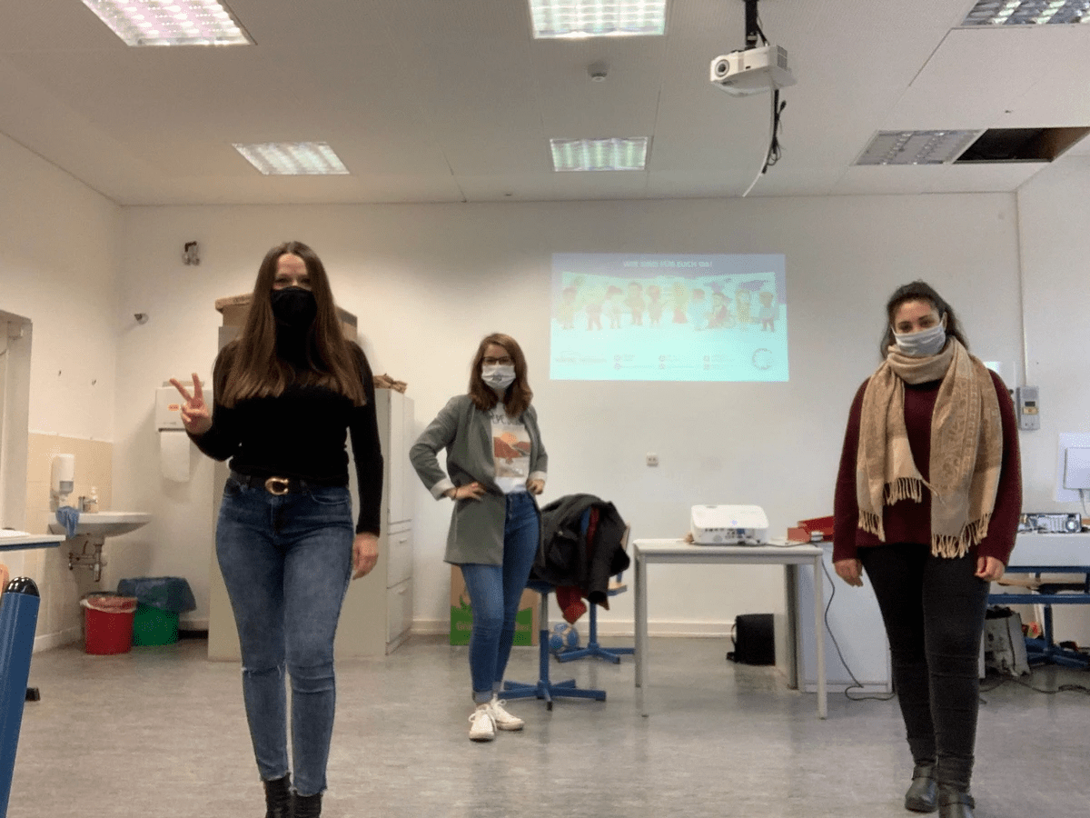 Unsere drei Trainerinnen mit Atemmaske im Klassenzimmer Unsere drei Trainerinnen mit Atemmaske im Klassenzimmer