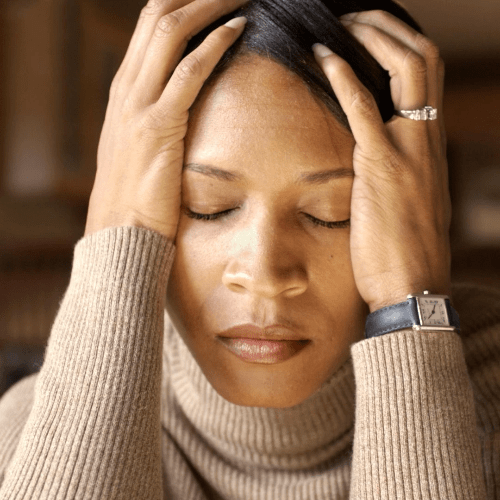 A woman puts her head in her hands, stressed and worried. A woman puts her head in her hands, stressed and worried.