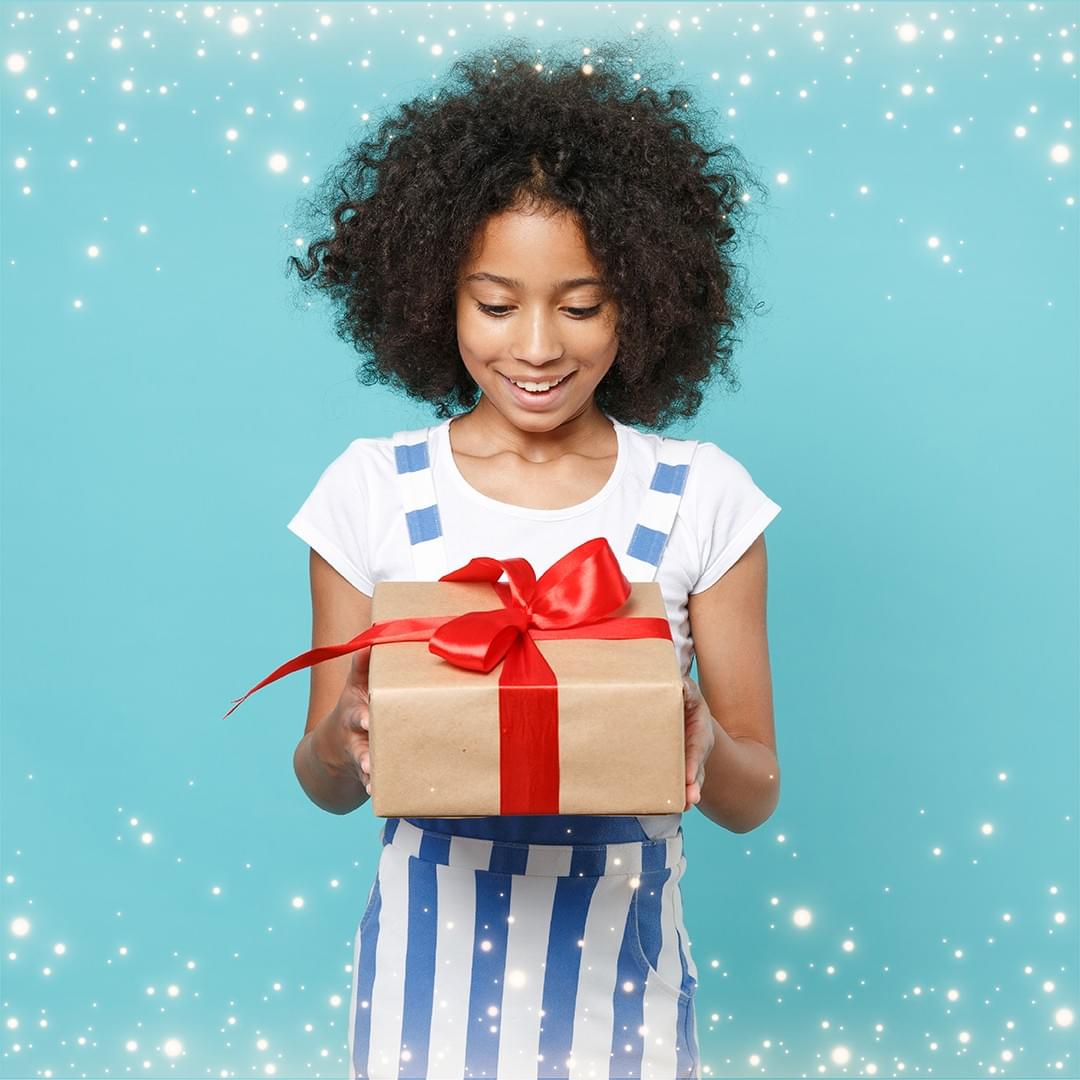 girl excitedly looking at a wrapped present girl excitedly looking at a wrapped present