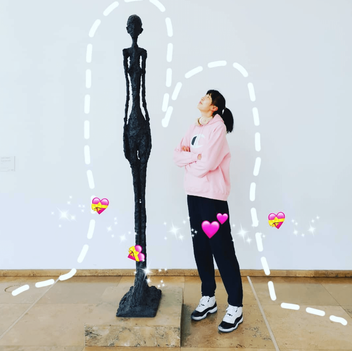Han Xu looks up at statue of a tall thin figure, with overlay of various heart emojis Han Xu looks up at statue of a tall thin figure, with overlay of various heart emojis