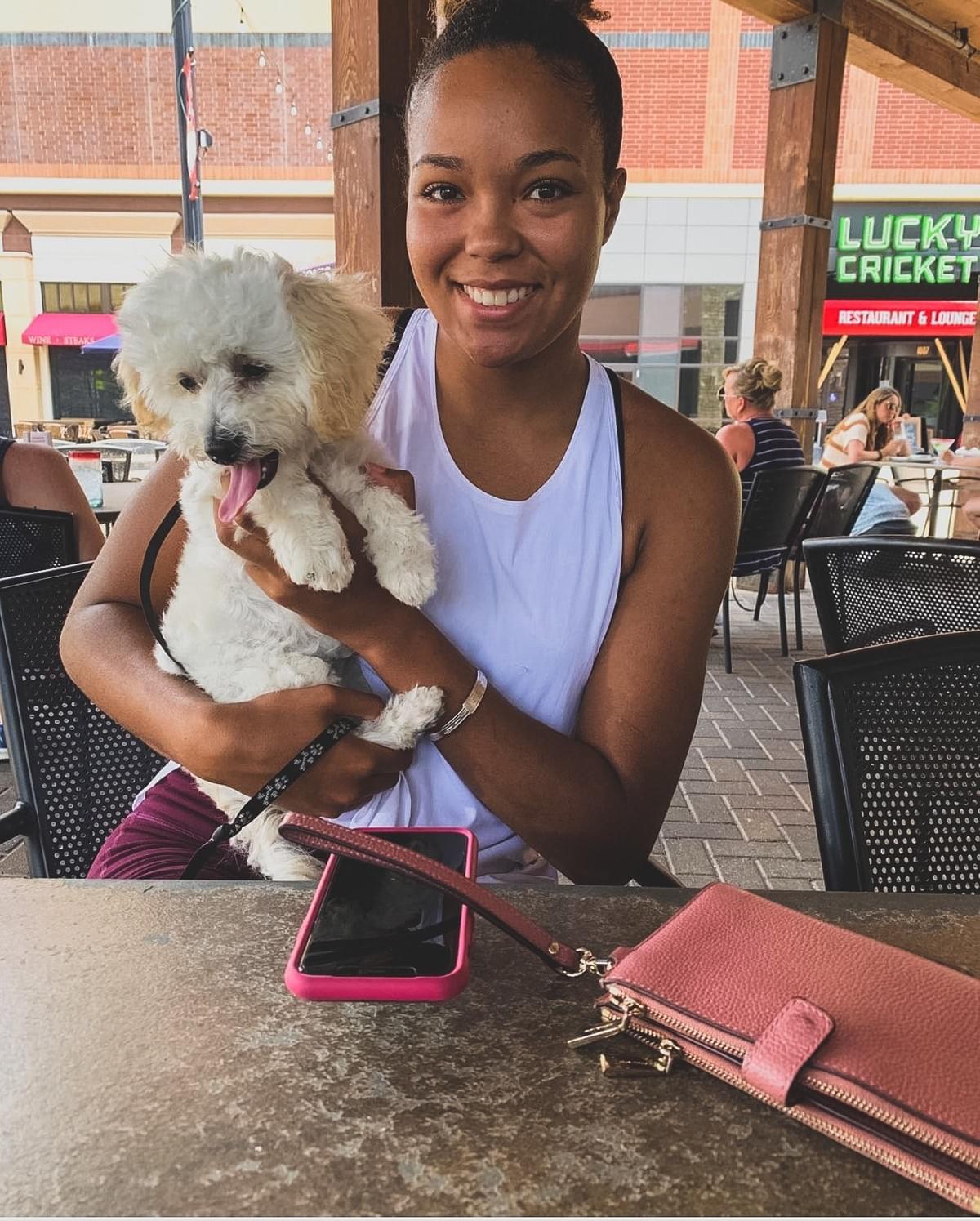 Napheesa Collier holds small white dog, whose tongue is sticking out. Napheesa Collier holds small white dog, whose tongue is sticking out.