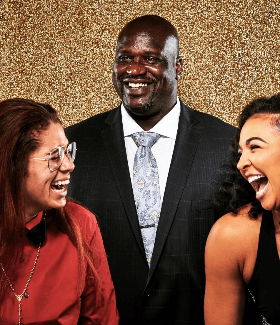 Photo of Amanda, Shaq, and Kiah Stokes laughing in front of glitter background Photo of Amanda, Shaq, and Kiah Stokes laughing in front of glitter background