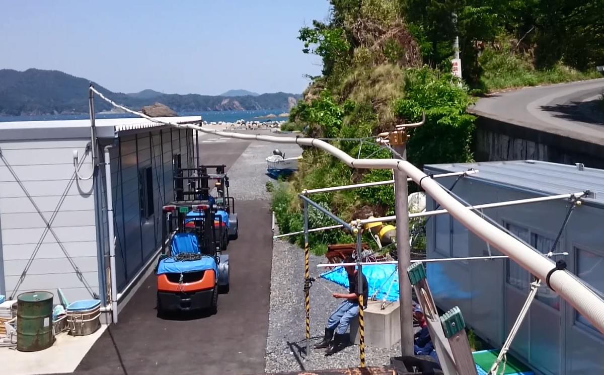 漁具を入れているコンテナから番屋まで、防犯カメラのケーブルを架空配線 漁具を入れているコンテナから番屋まで、防犯カメラのケーブルを架空配線