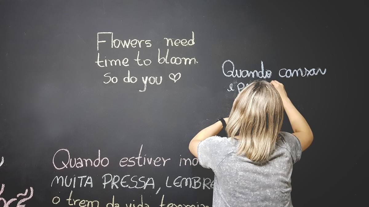 woman writing on chalk board - arts in learning woman writing on chalk board - arts in learning