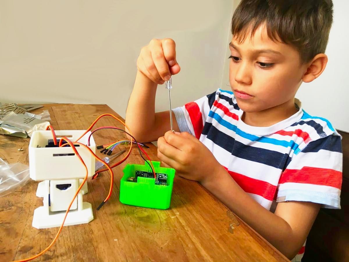 a child building a do it yourself robot on a desk a child building a do it yourself robot on a desk