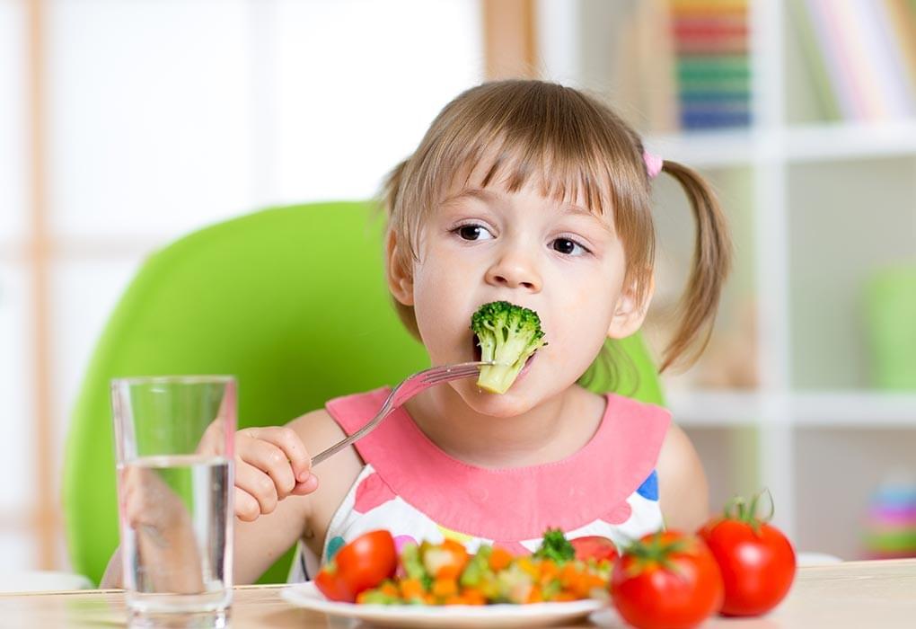 Child eating healthy food such as broccoli Child eating healthy food such as broccoli