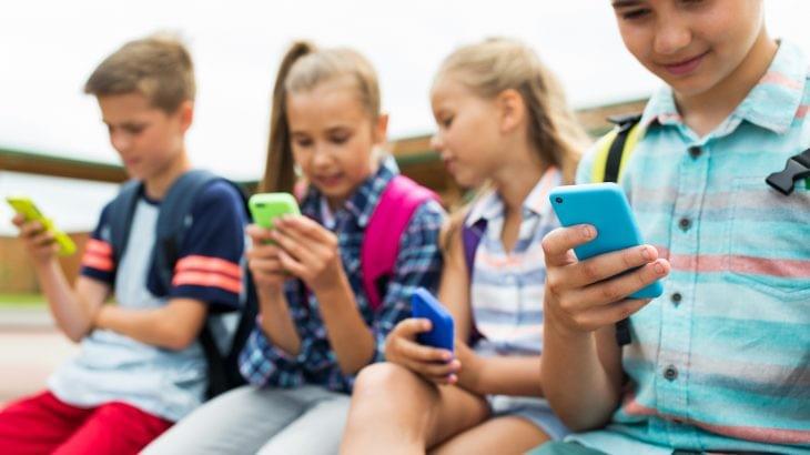 Children busy on their phones Children busy on their phones