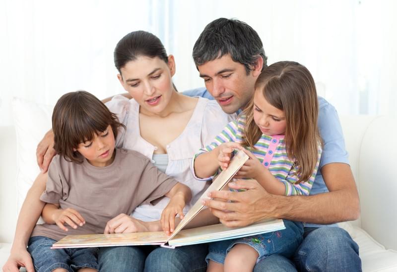 A family of four reading together A family of four reading together