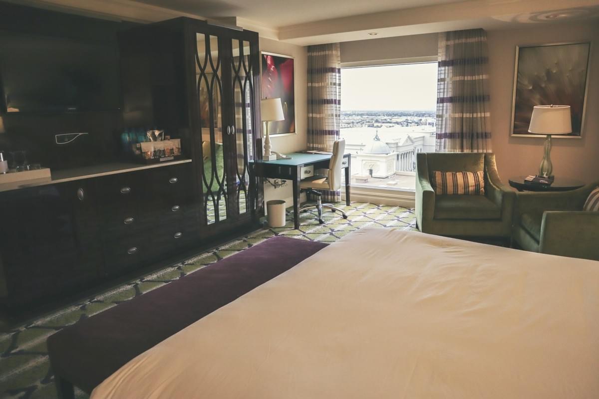 A bellagio hotel and resort bedroom hotel style with television, desk, art, with a view from the window also chairs, bed, chaise A bellagio hotel and resort bedroom hotel style with television, desk, art, with a view from the window also chairs, bed, chaise