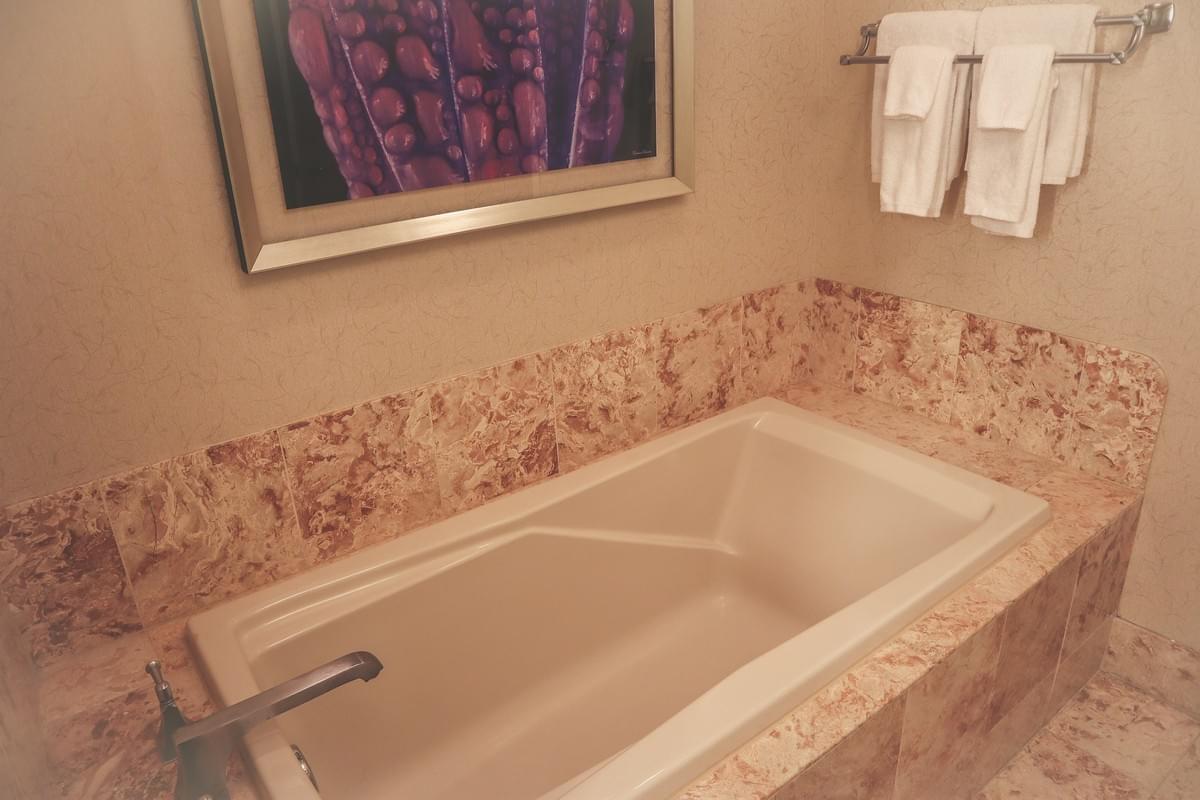 A hotel style bathroom bathtub with towels and art in a hotel room at the bellagio resort A hotel style bathroom bathtub with towels and art in a hotel room at the bellagio resort