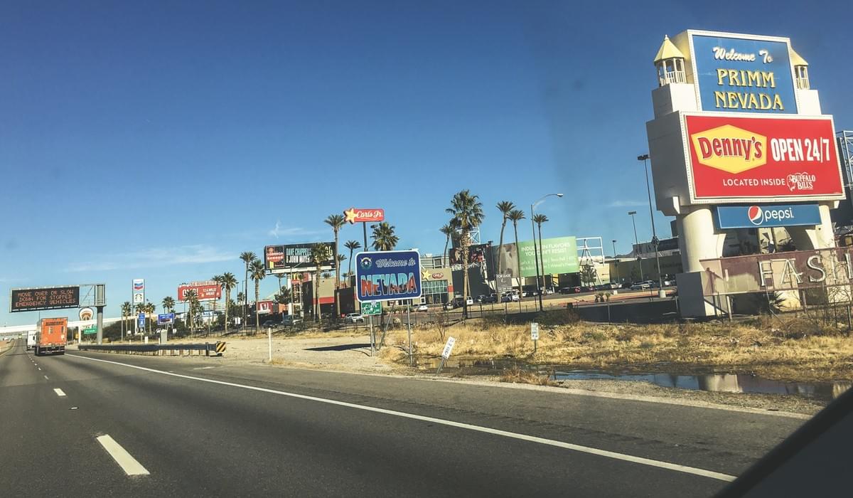 Welcome to Nevada sign at Stateline, Primm, Nevada, from the highway in a car during a road trip Welcome to Nevada sign at Stateline, Primm, Nevada, from the highway in a car during a road trip