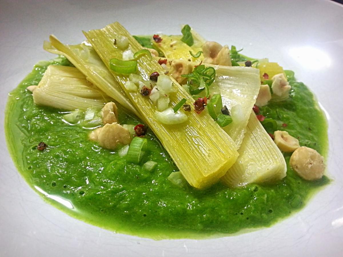Poireaux braisés à l'orange et noisettes sur une crème de verts de poireaux. Poireaux braisés à l'orange et noisettes sur une crème de verts de poireaux.